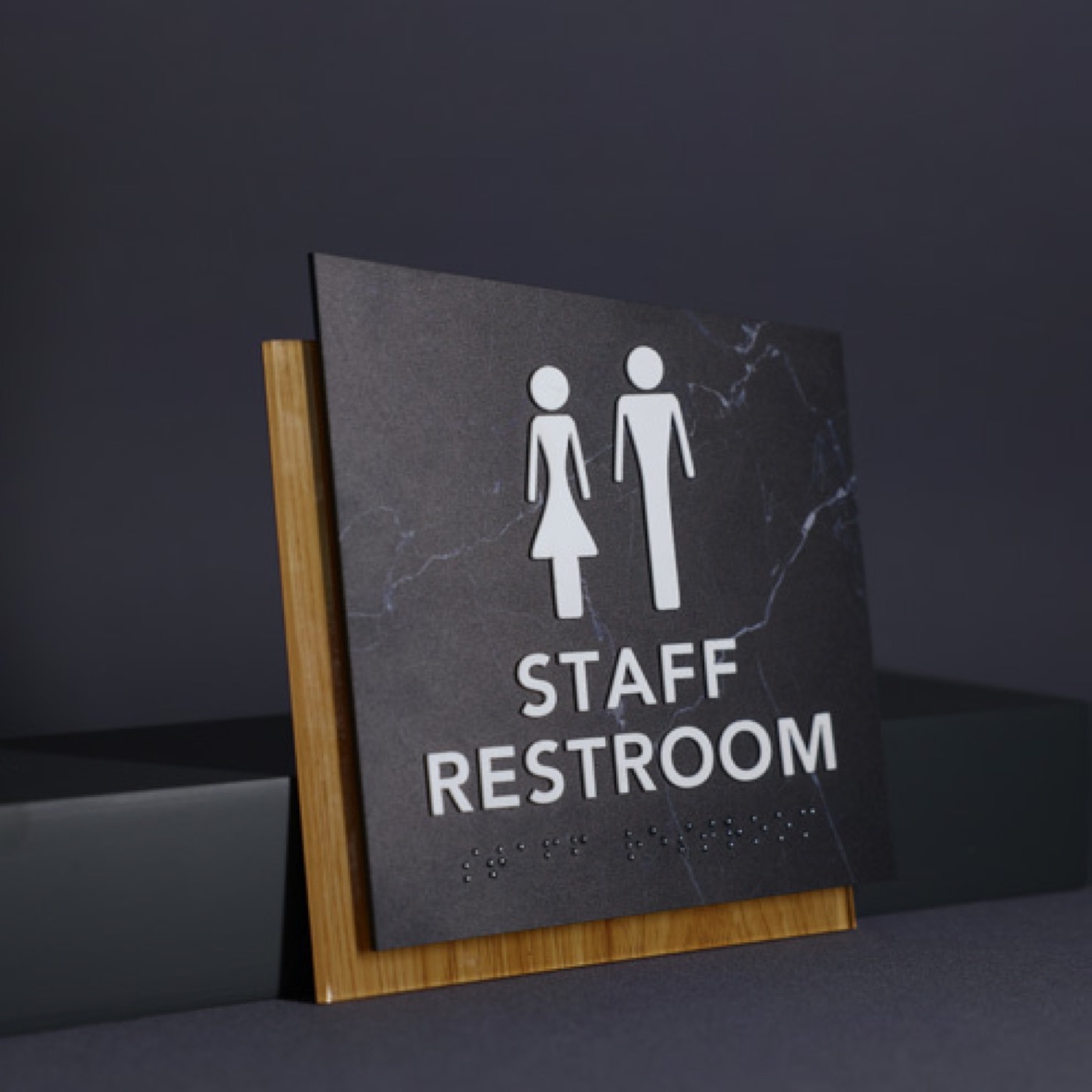 Piktogramskilt med symbol for toilet og mødelokale på kontorvæg