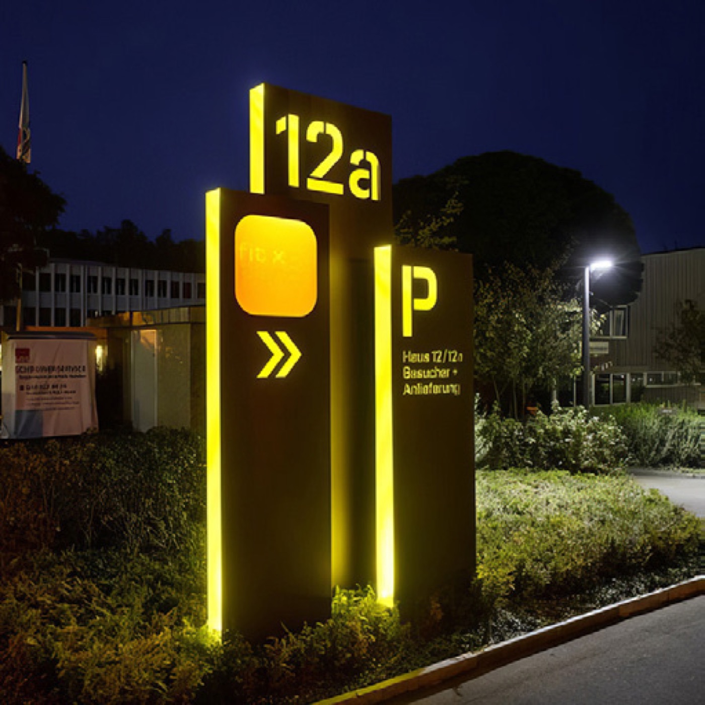 Belyst wayfinding-skilt der lyser klart om aftenen ved en p-plads